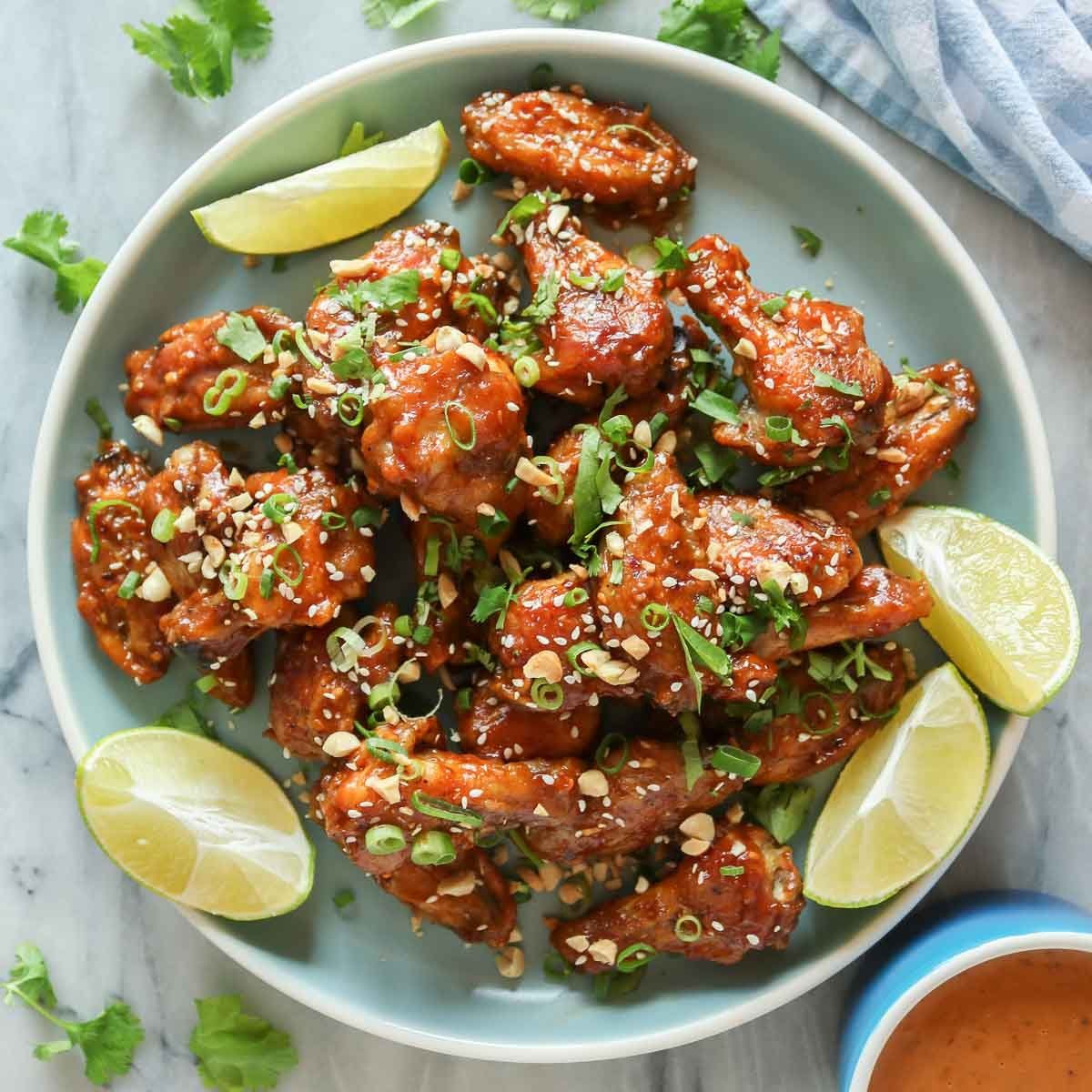 Gambas ou morceaux de poulet frits nappés de confiture de piment, garnis de graines et ciboulette, avec quartiers de citron et sauce à côté. Confiture de piment utilisation intégrée.